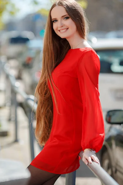 Young beautiful woman standing in the city street with new car on the background — Stock Photo, Image