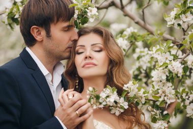 Gelin ve damat - bahar çiçekli bir parkta fotoğraf.