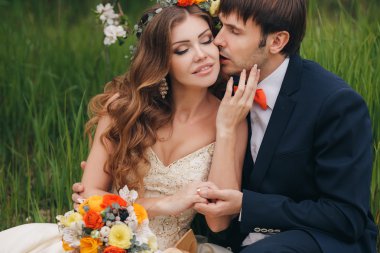 Damat gelini çiçekli parkta baharda kisses.