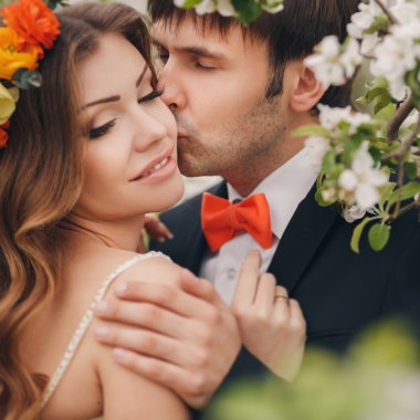 Gelin ve damat - bahar çiçekli bir parkta fotoğraf.