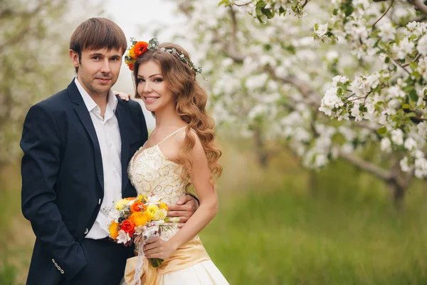 Mireasa și mirele - fotografie într-un parc de flori în primăvară . — Fotografie, imagine de stoc