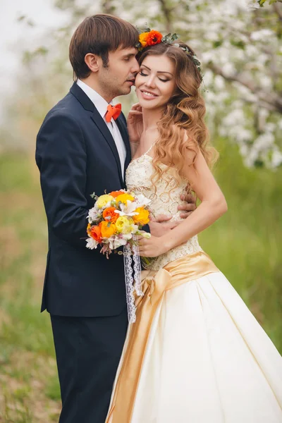 A noiva e o noivo - foto em um Parque florido na primavera . — Fotografia de Stock