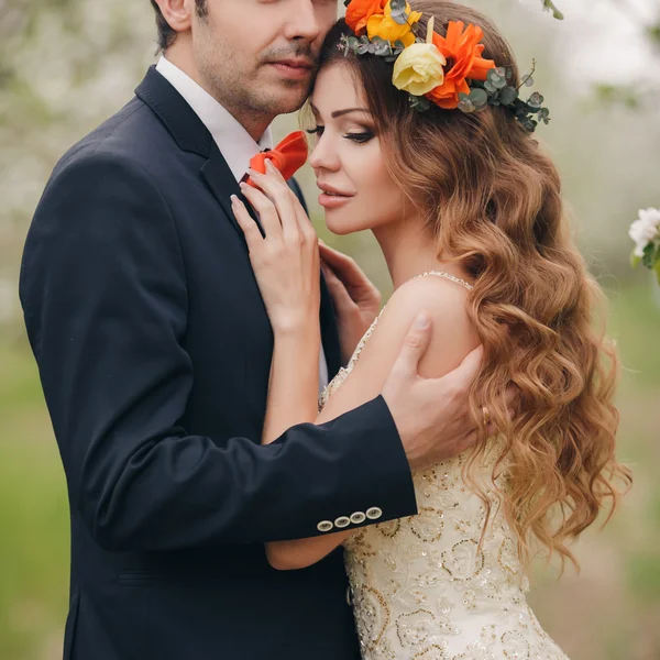 De bruid en bruidegom - foto in een bloemrijke Park in de lente. — Stockfoto