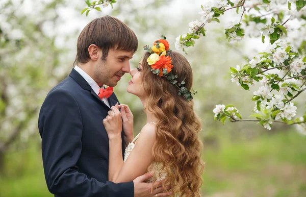 Gelin ve damat - bahar çiçekli bir parkta fotoğraf. — Stok fotoğraf