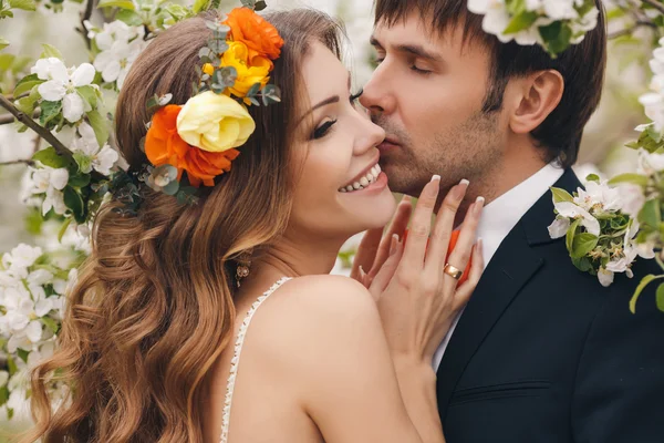 De bruid en bruidegom - foto in een bloemrijke Park in de lente. — Stockfoto