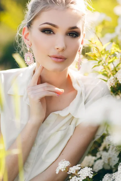 Schöne glückliche Frau in einem blumigen Frühlingsgarten. — Stockfoto