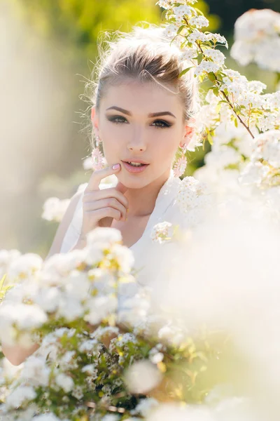 Krásná šťastná žena v jarní květinová zahrada. — Stock fotografie