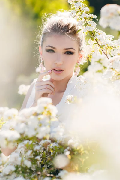 Mulher feliz bonita em um jardim de primavera florido . — Fotografia de Stock