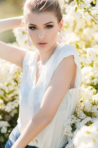 Mulher feliz bonita em um jardim de primavera florido . — Fotografia de Stock