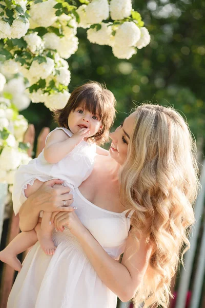 Retrato de mulher feliz com uma pequena filha na aldeia na primavera — Fotografia de Stock