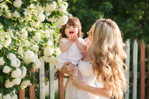 Retrato de mulher feliz com uma pequena filha na aldeia na primavera — Fotografia de Stock