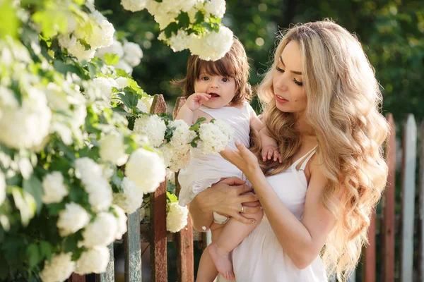 Portrait of happy woman with a small daughter in the village in the spring — Stock fotografie