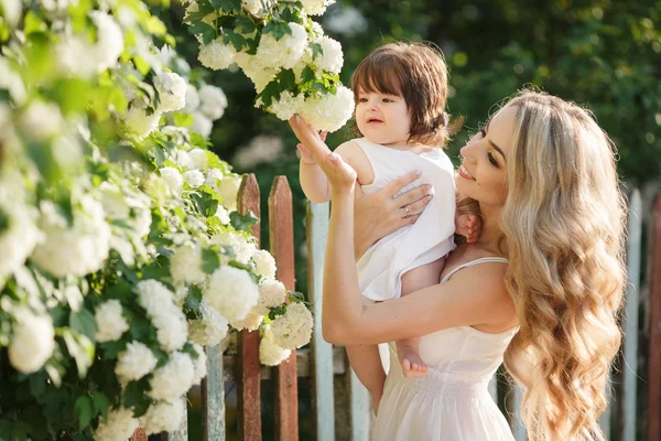 Retrato de mulher feliz com uma pequena filha na aldeia na primavera — Fotografia de Stock