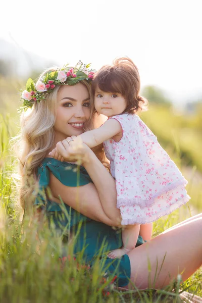 Donna felice con un bambino che riposa sulla natura — Foto Stock