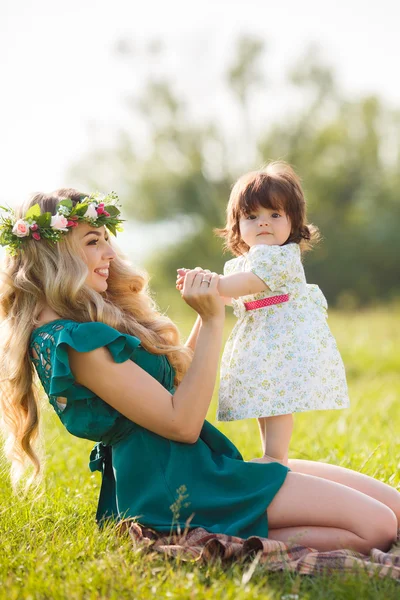 Glückliche Frau mit einem Kind, das sich auf der Natur ausruht — Stockfoto