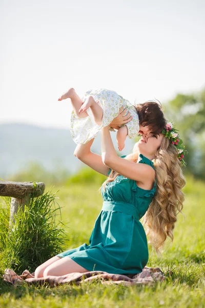 Gelukkige vrouw met een kind rustend op de aard — Stockfoto