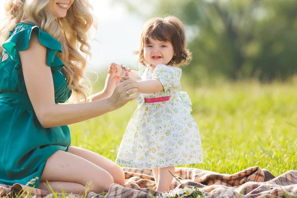 Gelukkige vrouw met een kind rustend op de aard — Stockfoto