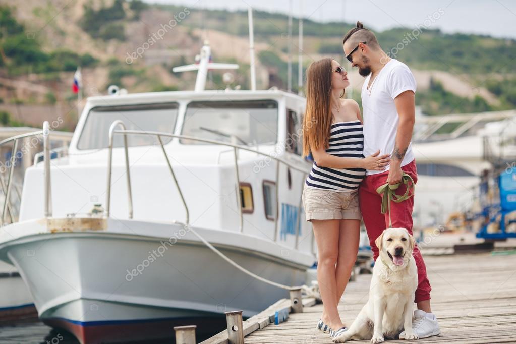 Young couple on a walk in the Harbor with a white Labrador