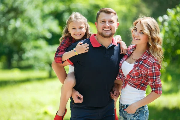 Happy family on a walk in a green Park in the summer. — Stockfoto