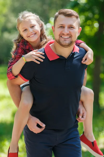 Отец играет со своей дочерью в зеленом летнем парке — стоковое фото