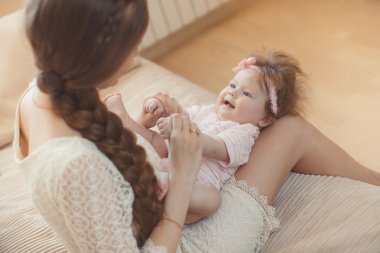 Happy mother playing with child at home