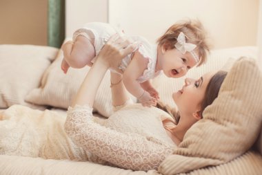 Happy mother playing with child at home