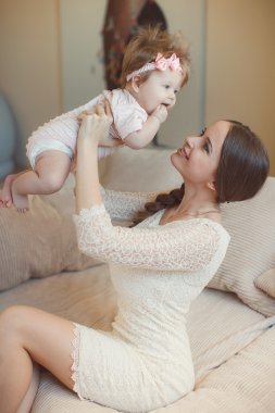 Happy mother playing with child at home