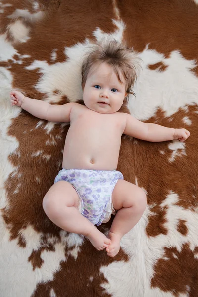 Bebê bonito com belos olhos azuis sorrindo deitado na cama — Fotografia de Stock