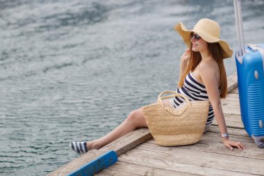 Pregnant beautiful woman on the pier at the sea