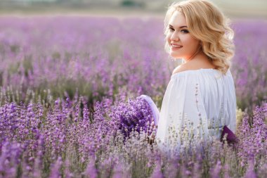 Beautiful woman in a field of blossoming lavender