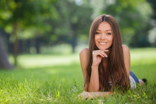 Bir küçük köpek yavrusu collie ile yeşil bir parkta oynayan genç güzel kadın