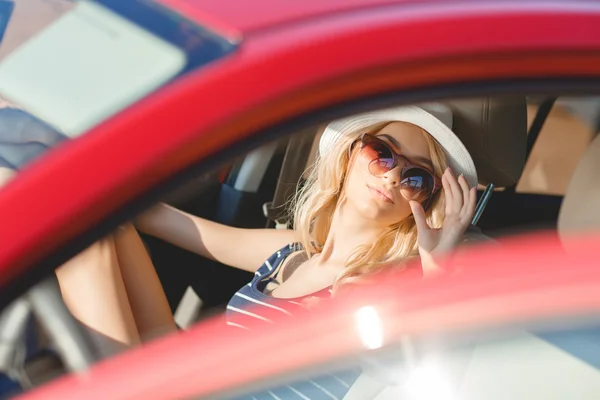 Beautiful blonde traveling in a red car. — Stock Photo, Image