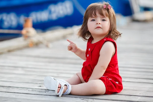 Meisje, zittend op een houten pier — Stockfoto