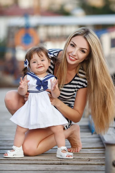 Glückliche Mutter mit der kleinen Tochter in der Nähe des Yachtclubs — Stockfoto