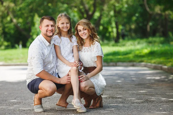 Glückliche junge Familie verbringt Zeit zusammen draußen in der grünen Natur — Stockfoto