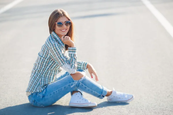 Alegre hermosa mujer sonriendo sentado en el camino —  Fotos de Stock