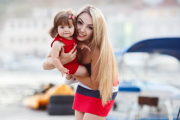 Joyeux jeune mère avec une jeune fille près du Yacht Club — Photo