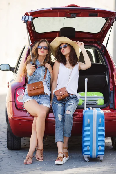 Селфи две подружки в багажнике машины — стоковое фото