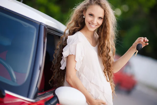 Pregnant brunette girl and her red car — Stock Photo, Image