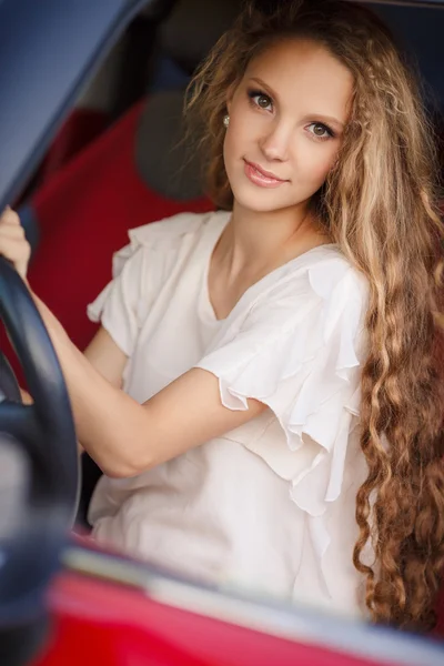 Chica morena embarazada y su coche rojo — Foto de Stock