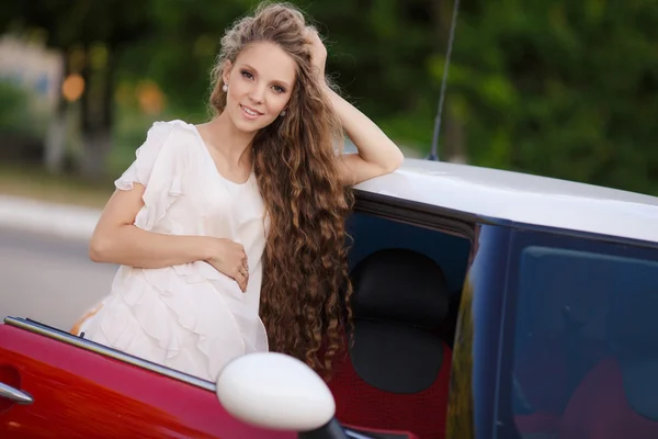 Gravid brunett tjej och hennes röda bil — Stockfoto