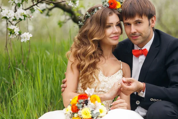 Retrato recém-casados no exuberante jardim de primavera — Fotografia de Stock