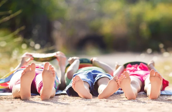 I bambini si sdraiano a terra nel parco e mangiano anguria — Foto Stock