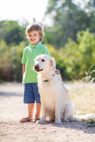 Niño con un perro en la naturaleza — Foto de Stock