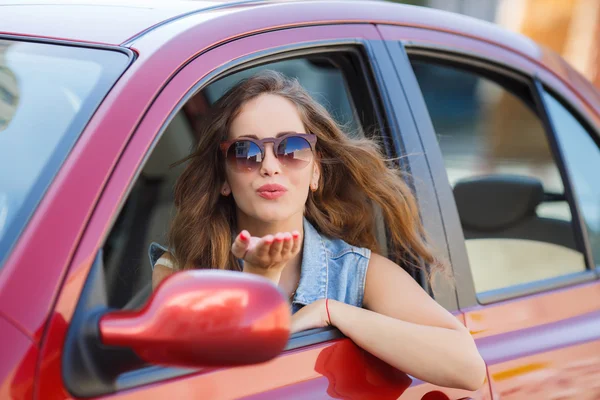 Glückliche junge Frau im Auto auf der Straße. — Stockfoto