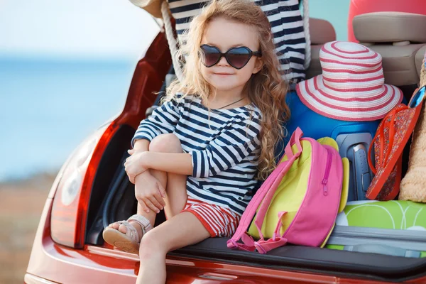 Bir arabanın bagajında oturan küçük bir kız portresi — Stok fotoğraf