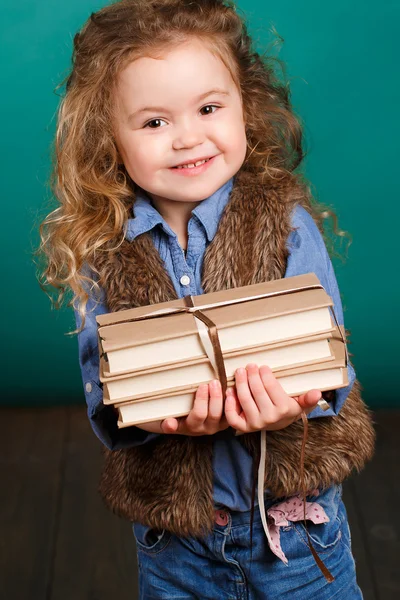 Pieni tyttö kirjojen kanssa. — kuvapankkivalokuva