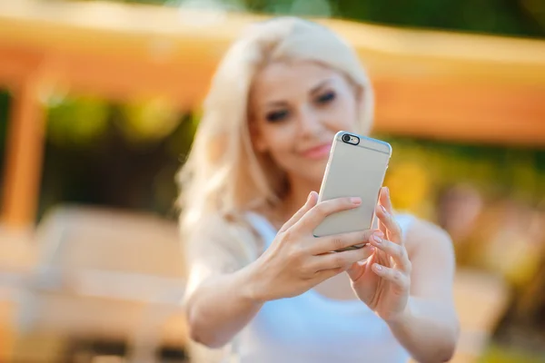 Feliz mujer sonriente usando su teléfono en la ciudad —  Fotos de Stock