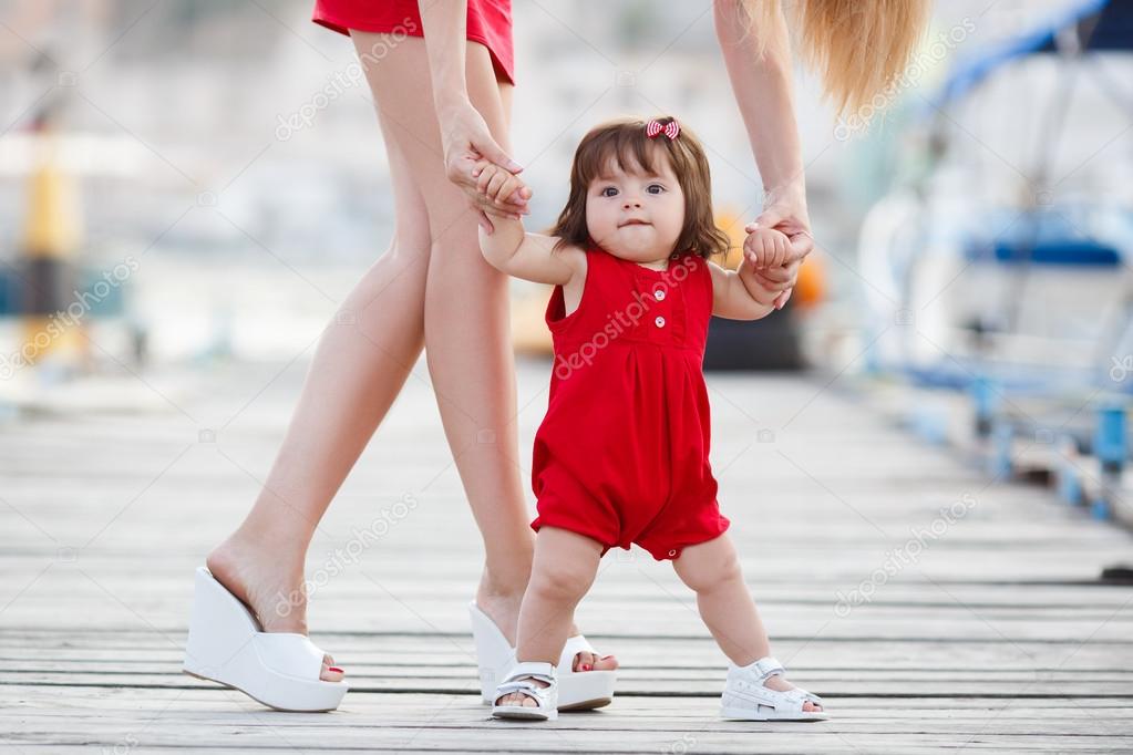 Mother and little daughter walking along the waterfront