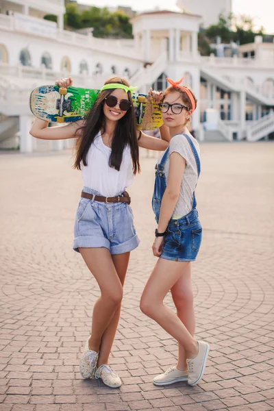 Two beautiful young girls on a skateboard in the city. — Φωτογραφία Αρχείου